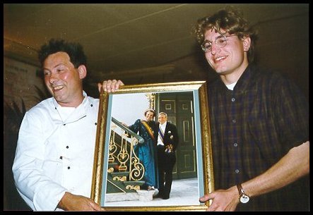 Twee mannen tonen een ingelijste foto als cadeau